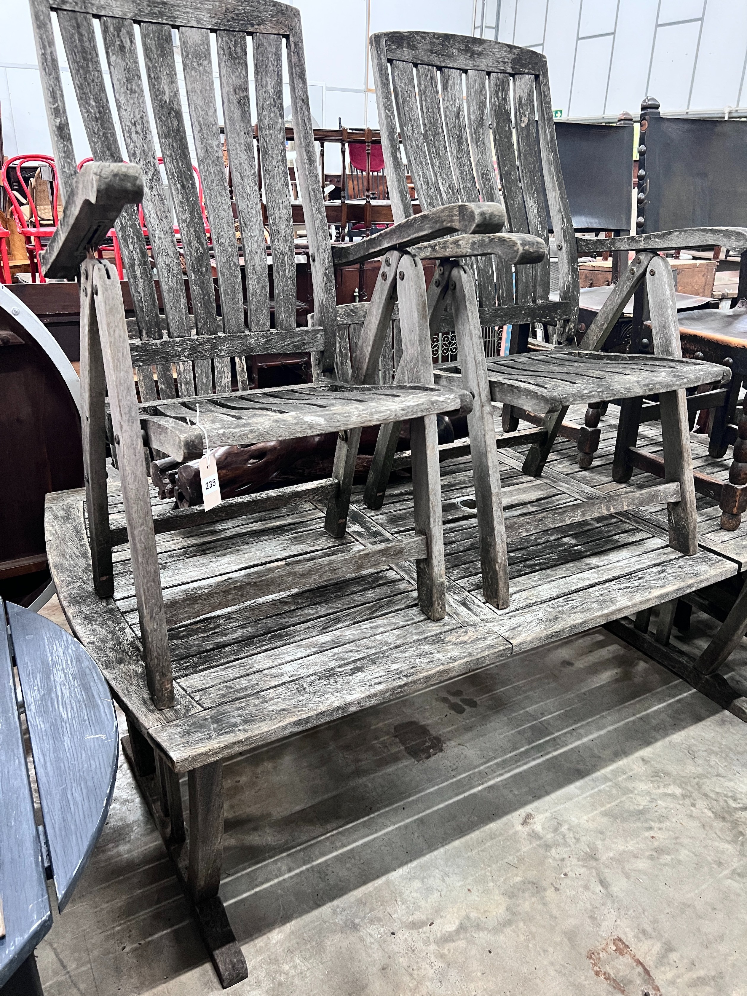 A weathered teak extending garden table with five matching folding armchairs, length 195cm, depth 110cm, height 76cm *Please note the sale commences at 9am.